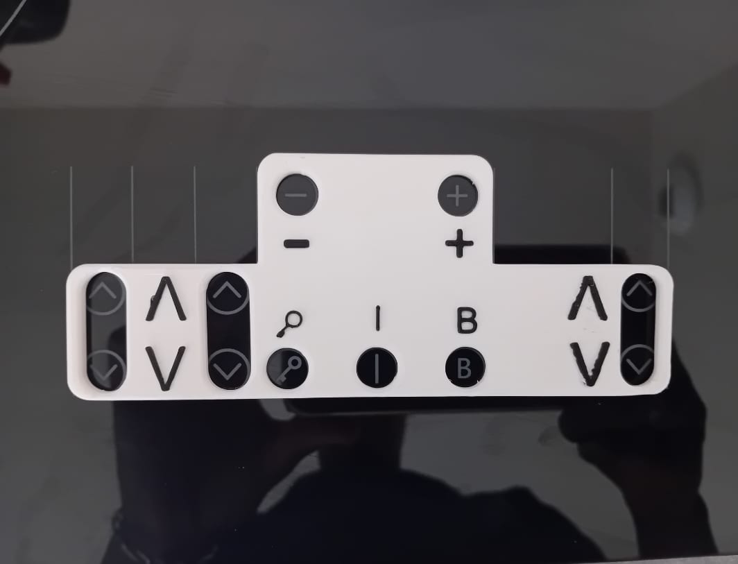 Le guide blanc posé sur le bandeau de commandes noir d'une plaque à induction